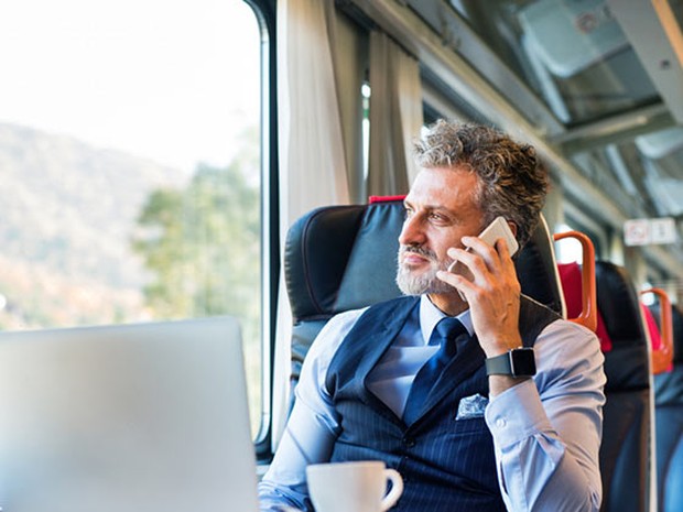 Hombre de mediana edad de negocios hablando por teléfono en el tren