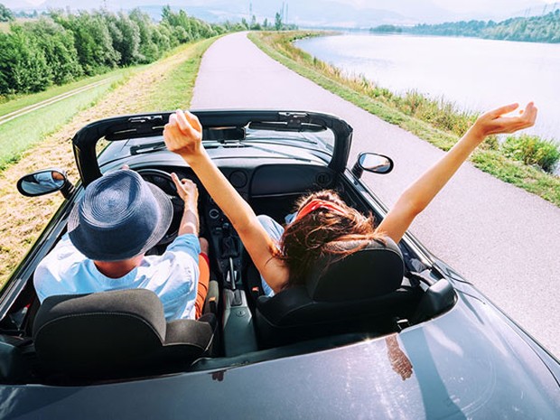 Dos personas conduciendo un coche descapotable