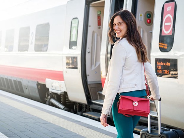 Chica sonriendo subiéndose a un tren