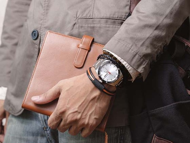 Hombre con bolso marrón de cuero, pulseras y un reloj