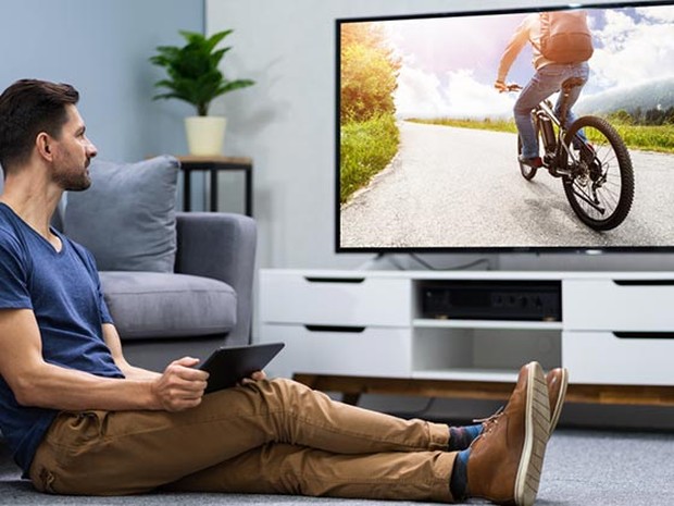 chico con un portátil y tele