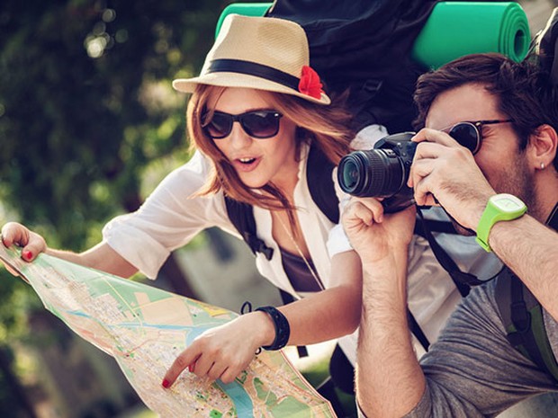Mujer y hombre turistas con un mapa y una cámara de fotos