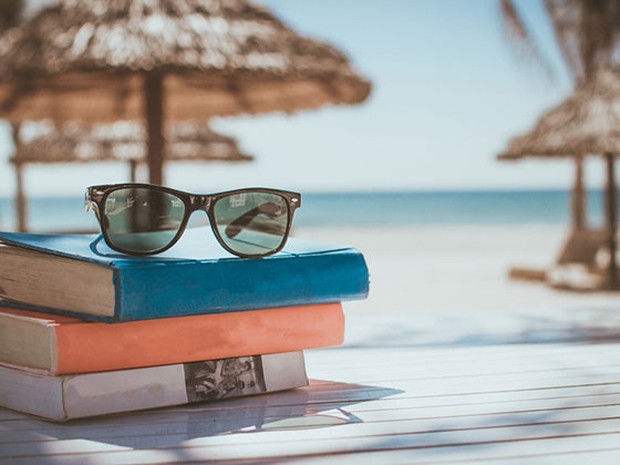 Libros sobre una mesa de madera en la playa