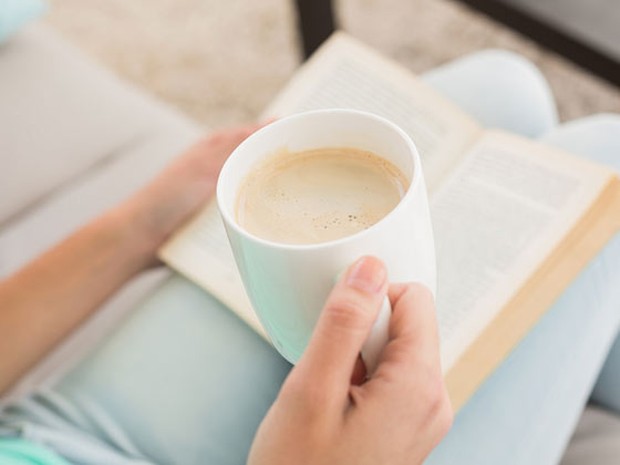 mujer leyendo con una taza de café