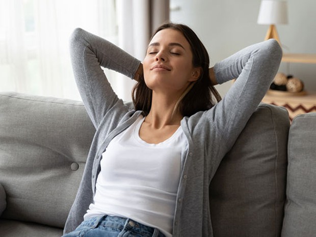 Mujer descansando sonriente en el sofá