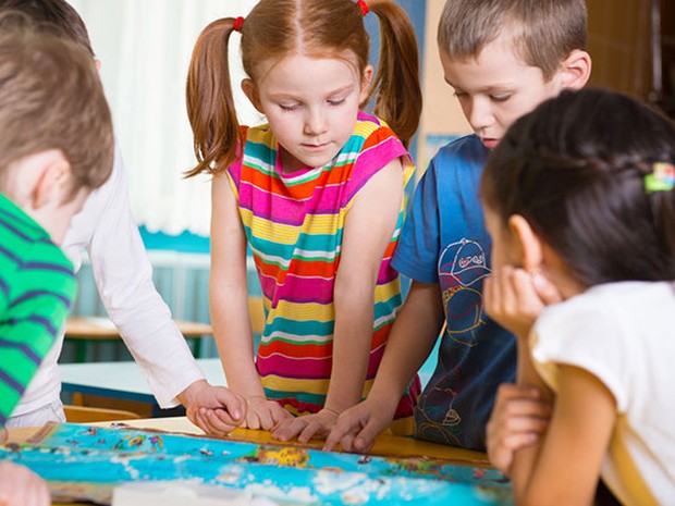 Varios niños jugando a un juego de mesa