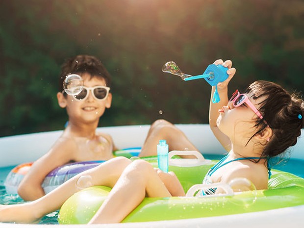 Dos niños jugando dentro de una piscina hinchable