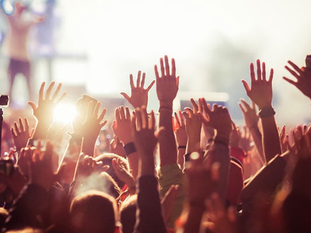 Personas con las manos alzadas en un festival de música