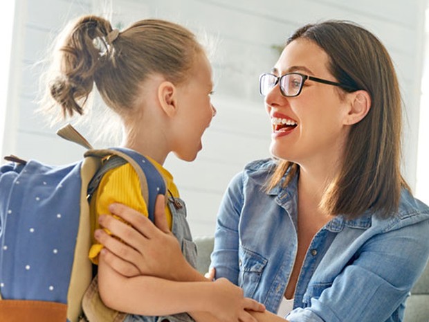 Niña con mochila escolar con su madre