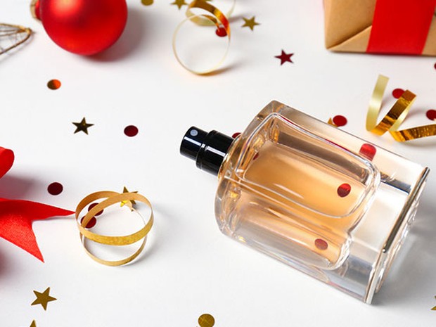 Perfume junto a decoración navideña y confeti