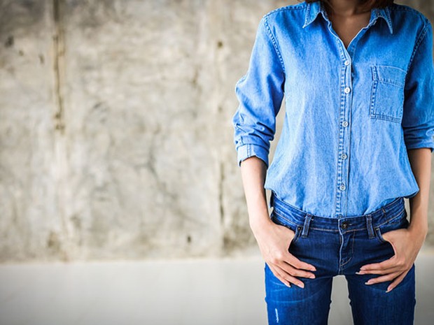 Mujer con una camisa vaquera de color claro y unos vaqueros pitillos más oscuros