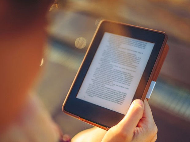 Persona leyendo en un libro electrónico con una funda marrón