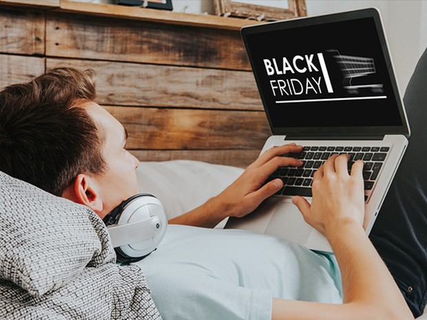 Hombre joven buscando en su mac promociones de Black Friday