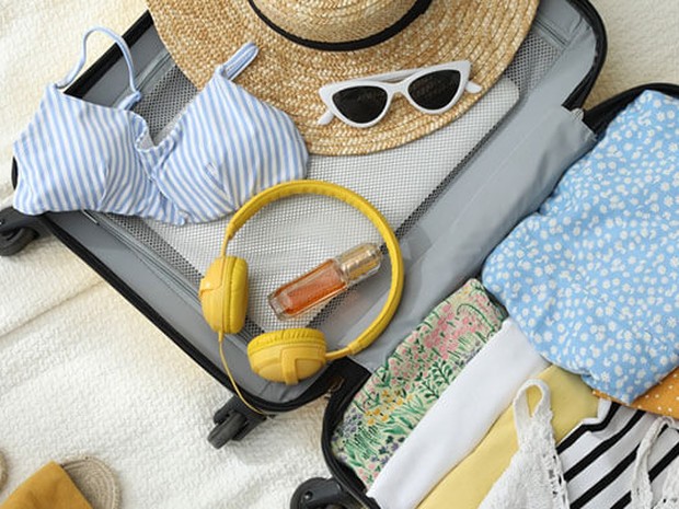 Maleta con ropa y accesorios de verano