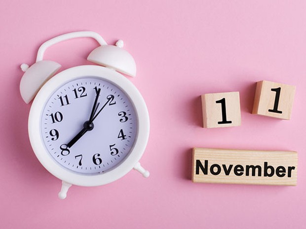 Reloj y cartel de madera con la fecha 11 de noviembre