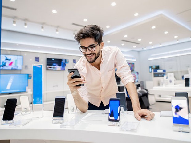 Hombre eligiendo un teléfono nuevo en una tienda
