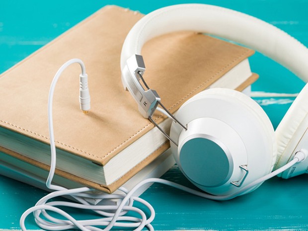 Auriculares de diadema enchufados a un libro