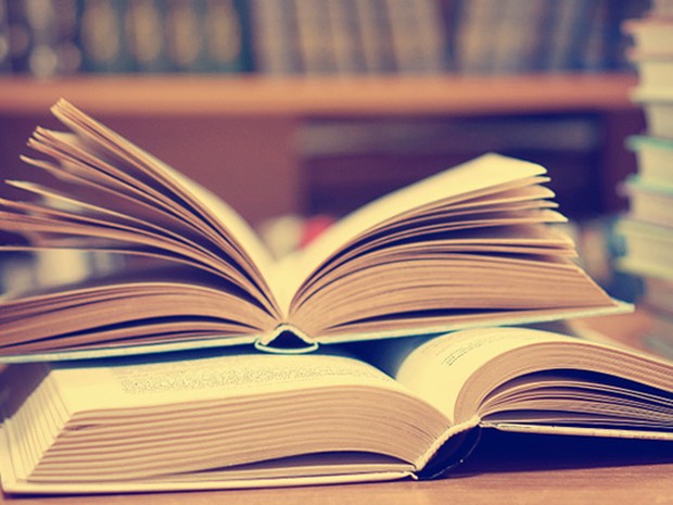 Conjunto de libros abiertos y cerrados sobre una mesa