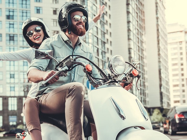 Pareja de jóvenes disfrutando de la ciudad en moto