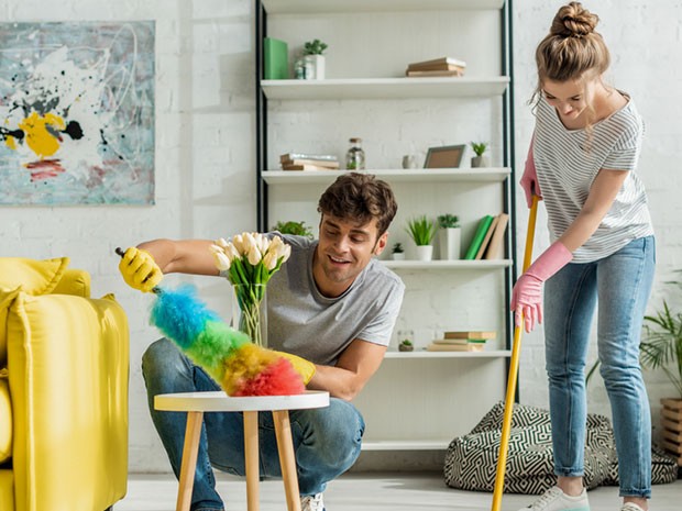 Pareja limpiando su casa