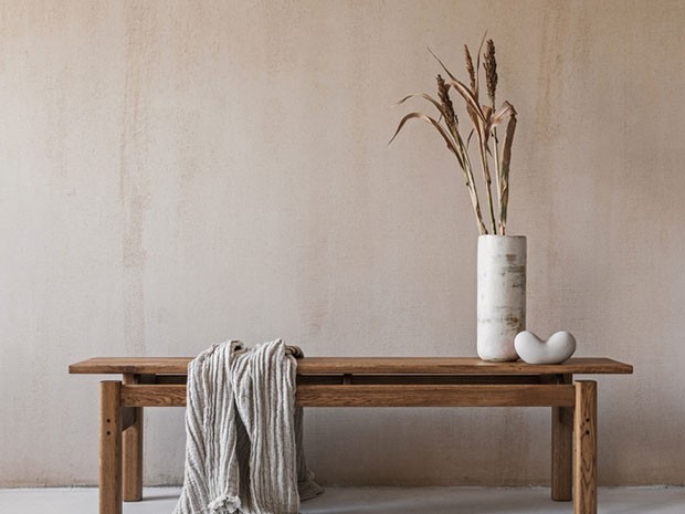 mesa de estilo raw con un jarrón y una manta