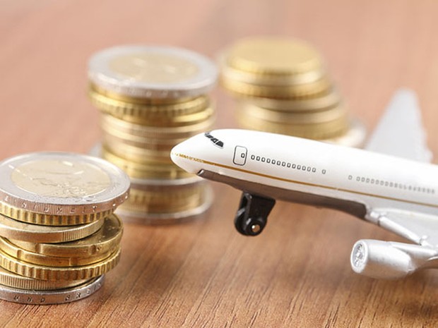 Avión de juguete junto a un montón de monedas de euro.