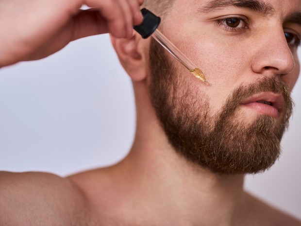 Hombre aplicando sérum en la barba