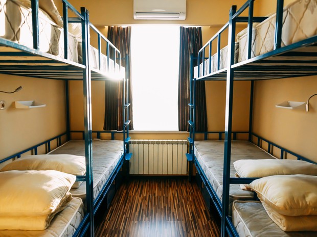 Habitación de un hostal de peregrinos con 4 literas con las camas sin hacer