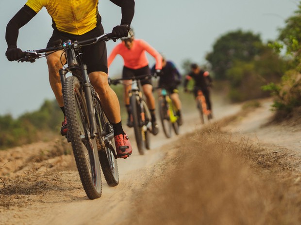 Grupo de 4 ciclistas con bicicletas de MTB por un camino de tierra