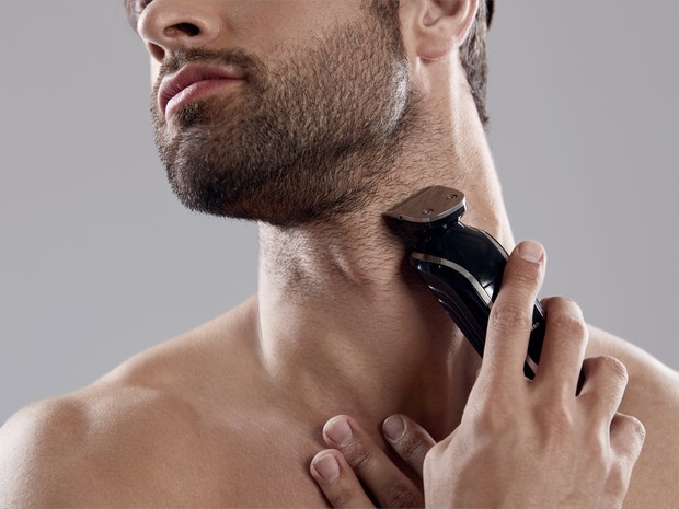Hombre afeitándose la barba con una afeitadora eléctrica