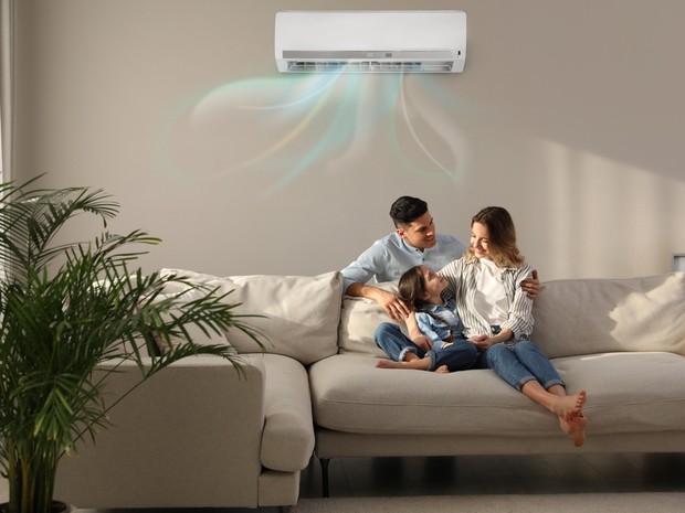 Familia de tres en el sofá disfrutando del aire acondicionado instalado en el techo