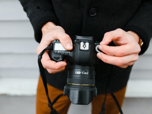 Las manos de un fotógrafo profesional ajusta una cámara antes de disparar