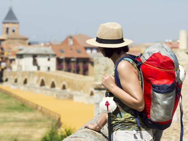 Peregrina con un gorro para protegerse del sol y una mochila roja