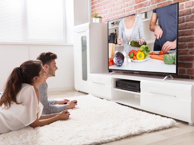 pareja viendo la tele tumbados en el suelo