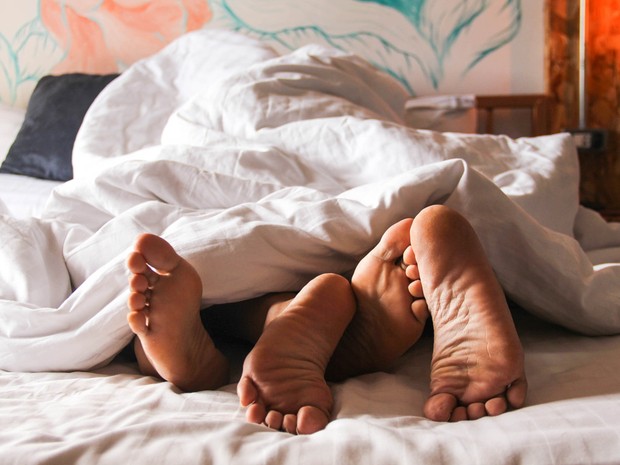 una pareja en la cama, solo se ven los pies entrelazados