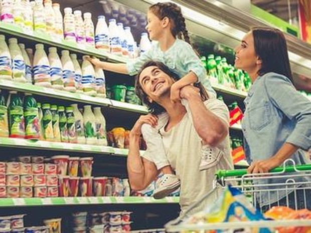 Padre, madre e hija en el supermercado haciendo la compra